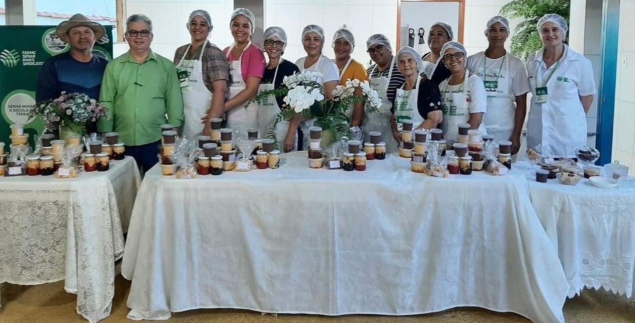 Turma do curso de doces e derivados com os produtos sobre a mesa